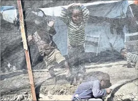  ?? THE ASSOCIATED PRESS FILE PHOTOS ?? Children play in the Moria refugee camp in May on the Aegean island of Lesbos, Greece.