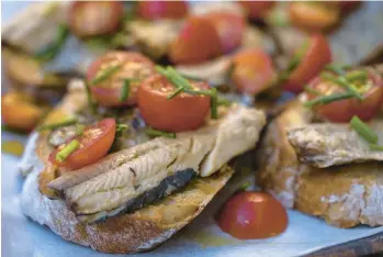  ?? ?? Sardines on toast with tomatoes, a classic take on Portugal’s common bread-and-fish dish at a bar in Porto.