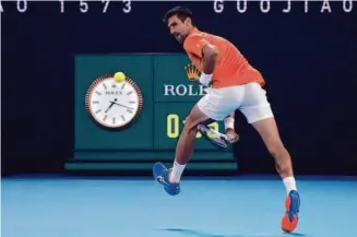  ?? Mark Baker/Associated Press ?? Serbia’s Novak Djokovic plays a shot between his legs during an exhibition match against Australia’s Nick Kyrgios ahead of the Australian Open in Melbourne.