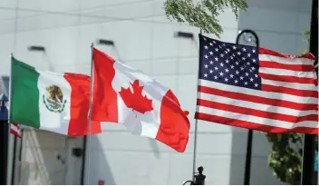  ?? — Reuters ?? Flags of the US, Canada and Mexico fly next to each other in Detroit, Michigan, US