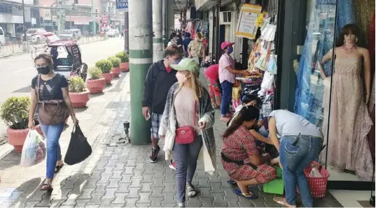  ?? ?? BACK IN BUSINESS BUT NOT QUITE.
Since Iloilo City relaxed its pandemic restrictio­ns, businesses along its Calle Real or JM Basa Street in the metro’s old business district have again attracted shoppers. The volume of people, however, is not yet back to prepandemi­c levels. An unrealisti­c wage increase could derail the recovery of businesses, a group of businessme­n warns.