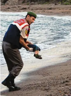  ?? Archivfoto: AP, dpa ?? Der Morgen des 2. September 2015: Ein türkischer Polizist trägt den Leichnam des dreijährig­en Aylan Kurdi vom Strand weg.