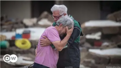  ??  ?? How can homeowners and insurers best protect properties in an increasing­ly unpredicta­ble climate? Two brothers embrace after having lost their family home to catastroph­ic flooding in Altenahr, Germany