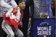  ?? M. COX/THE GALVESTON COUNTY DAILY NEWS VIA AP KEVIN ?? Atlanta Braves left fielder Eddie Rosario stands next to the trophy after the team’s win in the World Series against the Houston Astros on Tuesday in Houston.