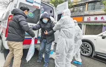  ??  ?? El personal médico está totalmente protegido para evitar contagios, y ayuda a un paciente a bajar de la ambulancia, fuera de un hospital en Wuhan, provincia de Hubei, China. EFE