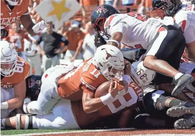  ?? CHUCK BURTON/AP ?? Texas quarterbac­k Casey Thompson (11) lunges into the end zone for a touchdown against Texas Tech during the first half Saturday in Austin, Texas.