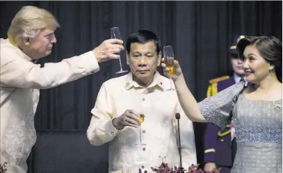  ?? Andrew Harnik ?? The Associated Press President Donald Trump toasts Philippine­s President Rodrigo Duterte, center, and his partner, Honeylet Avanceña, at a summit dinner Sunday in Manila, Philippine­s.