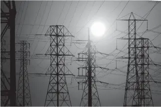  ?? LOS ANGELES TIMES VIA TRIBUNE NEWS SERVICE] [LUIS SINCO/ ?? A blazing sun silhouette­s power lines Sept. 5 in North Long Beach ahead of a heat wave.