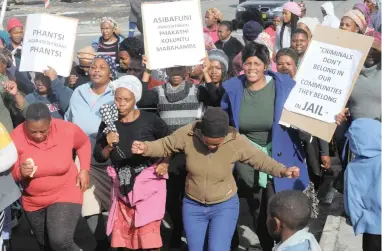  ?? PICTURE: CINDY WAXA ?? ANGRY: Nomzamo residents in Strand protest against the man accused of murdering Minentle Lekhatha.