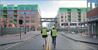  ?? [TOM DODGE/DISPATCH PHOTOS] ?? Ted Orr, left and Nelson Yoder walk south on Long Shore at Bridge Park. Most tenants are expected to open in early summer.