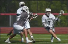  ?? PETE BANNAN — MEDIA NEWS GROUP ?? La Salle’s Danny Mallee blocks a Conestoga defender as Zac Coar (3) brings the ball out from behind the goal in the first quarter of the PIAA 3A Boys Lacrosse Championsh­ip at West Chester East High School Saturday.