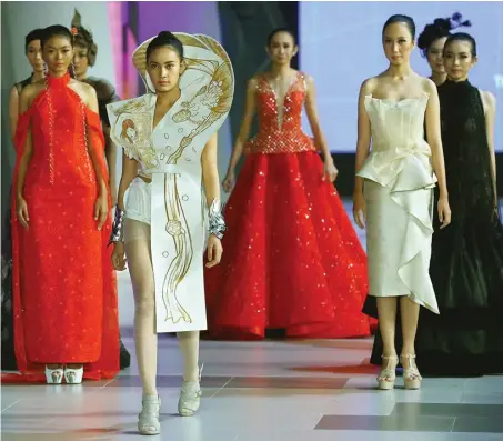  ?? DIPTA WAHYU/JAWA POS ?? PROYEK KOLABORASI: Gaun putih dengan aksen gambar komik (dua dari kiri) mengisi runway hari keempat Surabaya Fashion Parade 2018 kemarin (5/5).