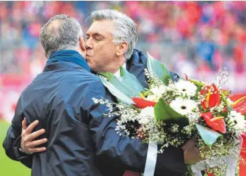  ?? FOTO: IMAGO ?? Von Karl-Heinz Rummenigge (li.) gab’s Blumen für Carlo Ancelottis 1000. Spiel. Von dem einen echten Männerkuss auf die Wange.