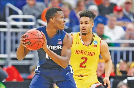  ?? THE ASSOCIATED PRESS ?? Xavier guard Malcolm Bernard looks for an opening past Maryland guard Melo Trimble during the first half of their NCAA tournament first round game on Thursday in Orlando, Fla. Xavier, the West Region’s No. 11 seed, won 76-65.