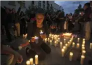  ?? THE ASSOCIATED PRESS ?? A woman lights a candle outside the presidenti­al house during a protest to demand justice for the girls who died in a fire at the Virgin of the Assumption Safe Home in Guatemala City on Thursday.