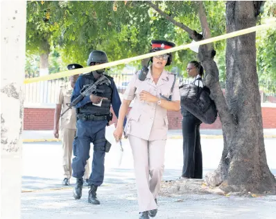  ??  ?? Members of the Jamaica Constabula­ry Force at the cordoned crime scene where an alleged thief was shot dead on Monday, March 23, at East Parade in the vicinity of Coke Memorial Methodist Church.