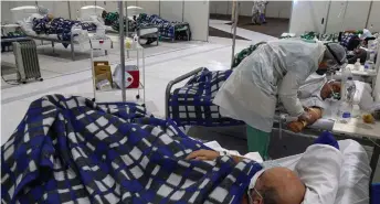  ?? — AFP photo ?? A health worker cares for a Covid-19-infected patient at the intensive care unit of Anhembi emergency makeshift hospital in Sao Paulo, Brazil.