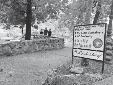  ?? [PHOTO BY RICHARD MIZE, THE OKLAHOMAN] ?? “No profanity,” the sign says, at the family friendly swimming hole in Medicine Park.