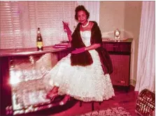  ?? Champagne coupe in her right hand. ?? A woman wears a strapless evening gown, pink gloves and glittery choker in this vintage slide from the collection. A mink stole is draped around her as she hold a