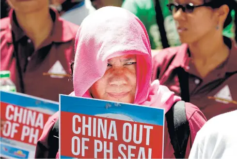  ?? AP ?? Protesters hold placards during a rally at the Chinese consulate to protest China’s artificial island-building on the disputed islands, reefs and shoals off the South China Sea last Monday in the financial district of Makati city, east of Manila,...