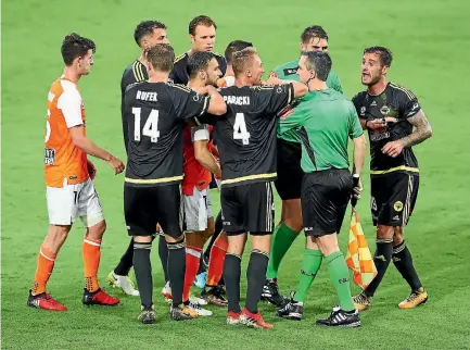  ?? PHOTOS: GETTY IMAGES ?? Wellington Phoenix and Brisbane Roar players clash on Saturday night after Phoenix defender Tom Doyle, right, was trodden on.