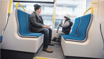  ?? MATHEW MCCARTHY WATERLOO REGION RECORD ?? Brian Limoyo and Leon Limoyo, 4, try out the seats in an Ion train at the Kitchener City Hall stop on Saturday.