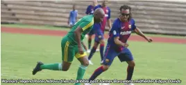  ??  ?? Warriors’ legend Peter Ndlovu tries to dribble past former Barcelona midfielder Edgar Davids