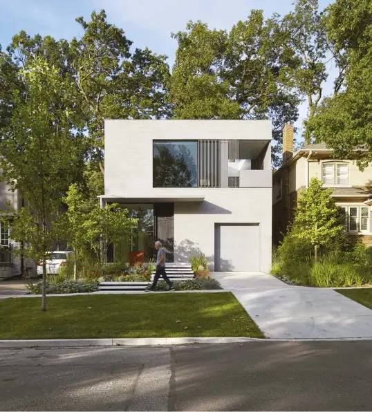  ??  ?? OPPOSITE PAGE Principals Andre D’elia and Meg Graham stand inside a recently completed residentia­l project (shown right). TOP Passersby stop regularly to check out this cubic house – dubbed “What Remains to Be Seen” – located at Bloor and Jane streets. The glazing and upper cut-out offer as many interior views as they do exterior. Landscape design by Fox Whyte.