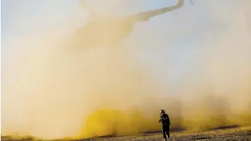  ?? (Marcus Yam/Los Angeles Times/TNS) ?? A SOLDIER with the Afghan army leaves the landing site as an Afghan Mi-17 takes off during training near Camp Shorab, in Helmand Province.