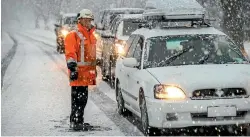  ?? PHOTO: MYTCHALL BRANSGROVE/TIMARU HERALD ?? John Wilson from Downer explains to drivers that the road to Kimpbell is closed in Timaru yesterday.