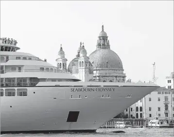  ?? ANDREW MEDICHINI/AP 2014 ?? A cruise ship passes in front of Saint Mark’s Square in Venice. The historic city is planning to divert large cruise ships .