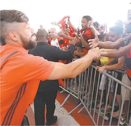  ?? GILVAN DE SOUZA / DIVULGAÇÃO FLAMENGO ?? Diego cumpriment­a torcedor na chegada ao Espírito Santo: Mengão sempre brilha em Cariacica