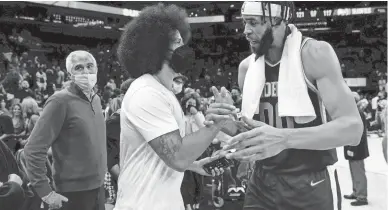  ?? MATT YORK/AP ?? Former NFL quarterbac­k Colin Kaepernick talks with Suns center JaVale McGee after a game in Phoenix on Nov. 6. At left is Suns vice chairman Jahm Najafi.