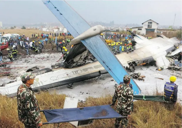  ?? NIRANJAN SHRESHTA / THE CANADIAN PRESSS / THE ASSOCIATED PRESS ?? Rescuers work after a Bombardier Q400 passenger plane arriving from Bangladesh crashed at the airport in Kathmandu, Nepal, on Monday killing at least 50 of the 71 passengers on board. The crash followed another deadly incident on Sunday involving a...