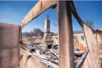  ?? NOAH BERGER/ASSOCIATED PRESS ?? A chimney stands amid rubble at a house scorched by a wildfire in Phelan, Calif. The wildfire chased thousands of residents from their mountain and desert homes.