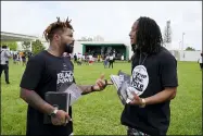  ?? MARTA LAVANDIER — THE ASSOCIATED PRESS ?? Phillip Agnew, left, a leader of Black Men Build, speaks with Robert Holness at a “Free the Vote” march to the polls, Saturday, Oct., in Miami. Get out the vote efforts targeting Black men aren’t just about persuading them to choose former Vice President Joe Biden over incumbent Donald Trump. “We are not choosing a champion, we are choosing an opponent,” says activist Agnew.