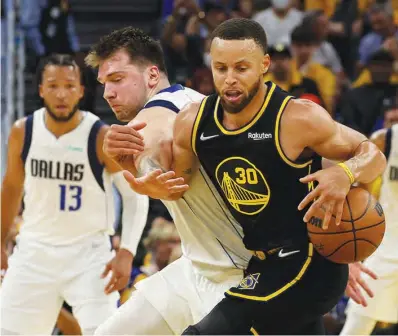  ?? ?? STEPHEN CURRY of Golden State protects the ball against Luka Doncic of Dallas during Game 1 of the NBA Western Conference Finals yesterday at Chase Center in San Francisco, California. (AFP)