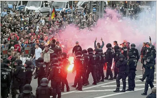  ??  ?? Rising tensions: Protesters lighting fireworks during the far-right demonstrat­ion in Chemnitz, Germany. — AP