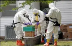  ??  ?? Federal agents wearing hazardous material suits and breathing apparatus inspect the home and possession­s in the West Hills Subdivisio­n house of Paul Kevin Curtis in Corinth, Miss., Friday, April 19, 2013. Curtis is in custody under the suspicion of...