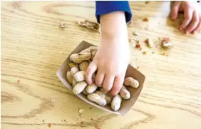  ?? GETTY IMAGES ?? A Child reaches for peanuts.