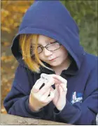  ??  ?? George Mayne Elementary fourth-grader August Gordon Hart inspects a block of salt.