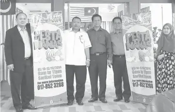  ??  ?? Dahim (second left) and (from left) Lim, Chan and Edwar with the Sarikei Pineapple Fest 2014 buntings.