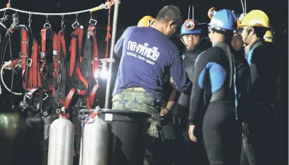  ?? — Reuters photo ?? Thai divers gather before they enter to the Tham Luang cave.