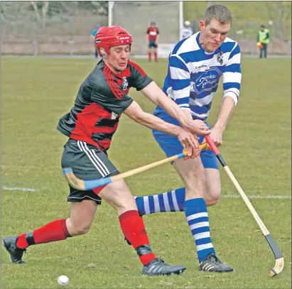  ??  ?? Oban Camanachd’s Garry Lord gets his block in against Newtonmore’s Fraser Mackintosh during last Saturday’s Marine Harvest Premiershi­p match at Mossfield which the Badenoch side won with the only goal of the game.