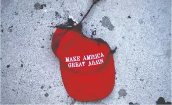  ?? LAWRENCE BRYANT/REUTERS ?? A burnt Make America Great Again hat lies on the ground during a protest against racial injustice near the site of President Donald Trump’s rally in Tulsa on June 20.