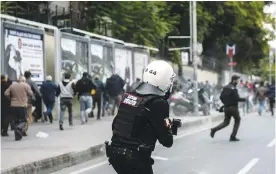  ??  ?? ISTANBUL: Turkish riot police officers fire rubber bullets to disperse pro-Kurdish Peoples’ Democracy Party (HDP) supporters during a demonstrat­ion in Istanbul, following the arrests of the two co-mayors in Diyarbakir. — AFP