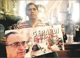  ??  ?? Una mujer sostiene un cartel del obispo, en la catedral de la Ciudad de Guatemala