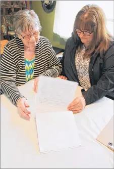  ?? SUEANN MUSICK/THE NEWS ?? Barb Poirier, left, and Deborah Geck look over the names they have collected on a petition they will be presenting to the Town of Pictou in hopes of getting a barricade removed on Veterans Drive. About 100 people have signed the petition in a short...