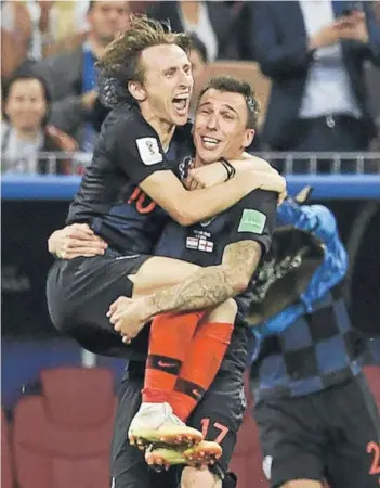  ??  ?? ► Modric se abraza con Mandzukic tras la victoria a Inglaterra.