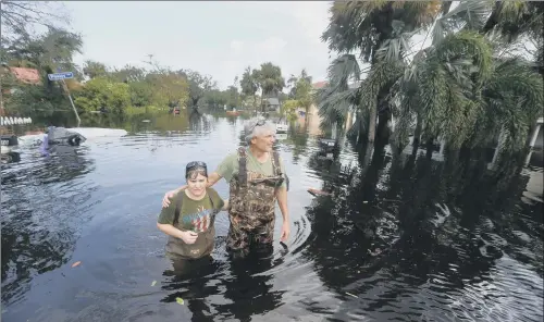  ?? PICTURES: AP PHOTO/GERALD HERBERT. ?? UNDER WATER: Kelly McClenthen returns to see the flood damage to her home with her boyfriend Daniel Harrison in the aftermath of Hurricane Irma in Bonita Springs, Florida, yesterday. The hurricane was downgraded to a tropical storm yesterday after...